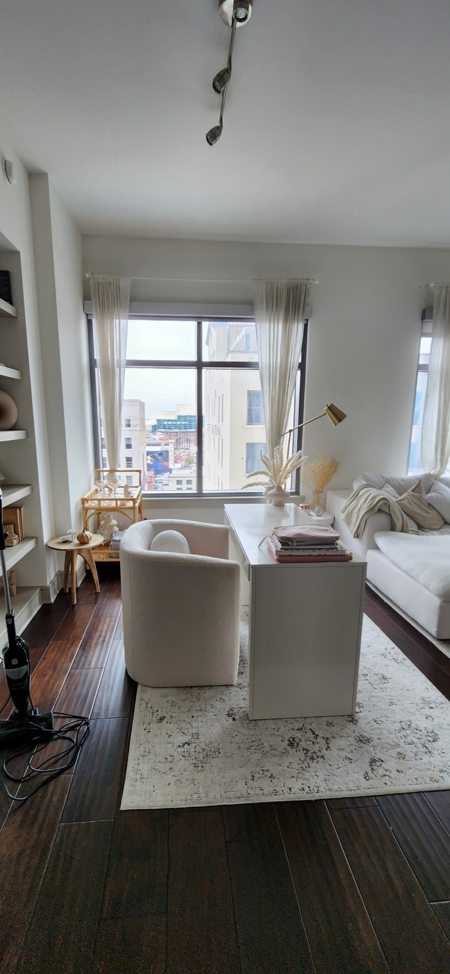 Clean, bright apartment corner with a white desk and tidy window area in Houston