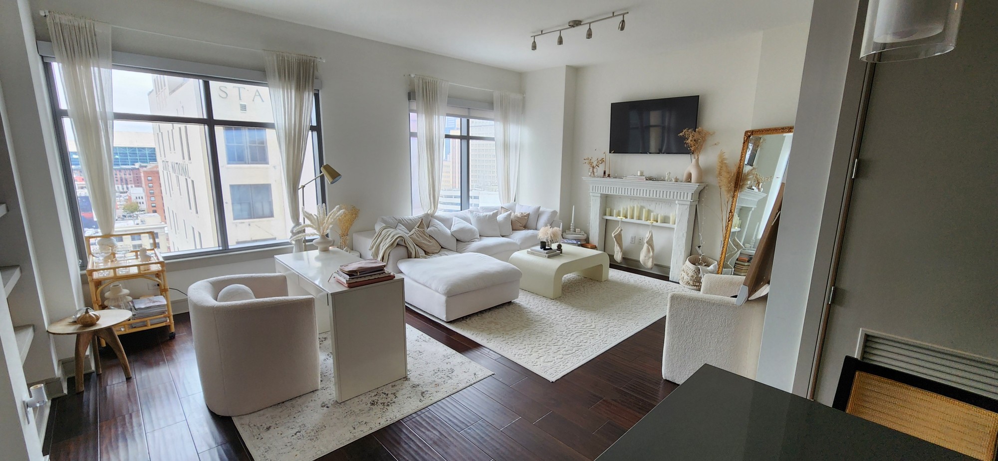 Spotless Houston apartment living room with white furniture and dark hardwood floors, cleaned by Fouro Living