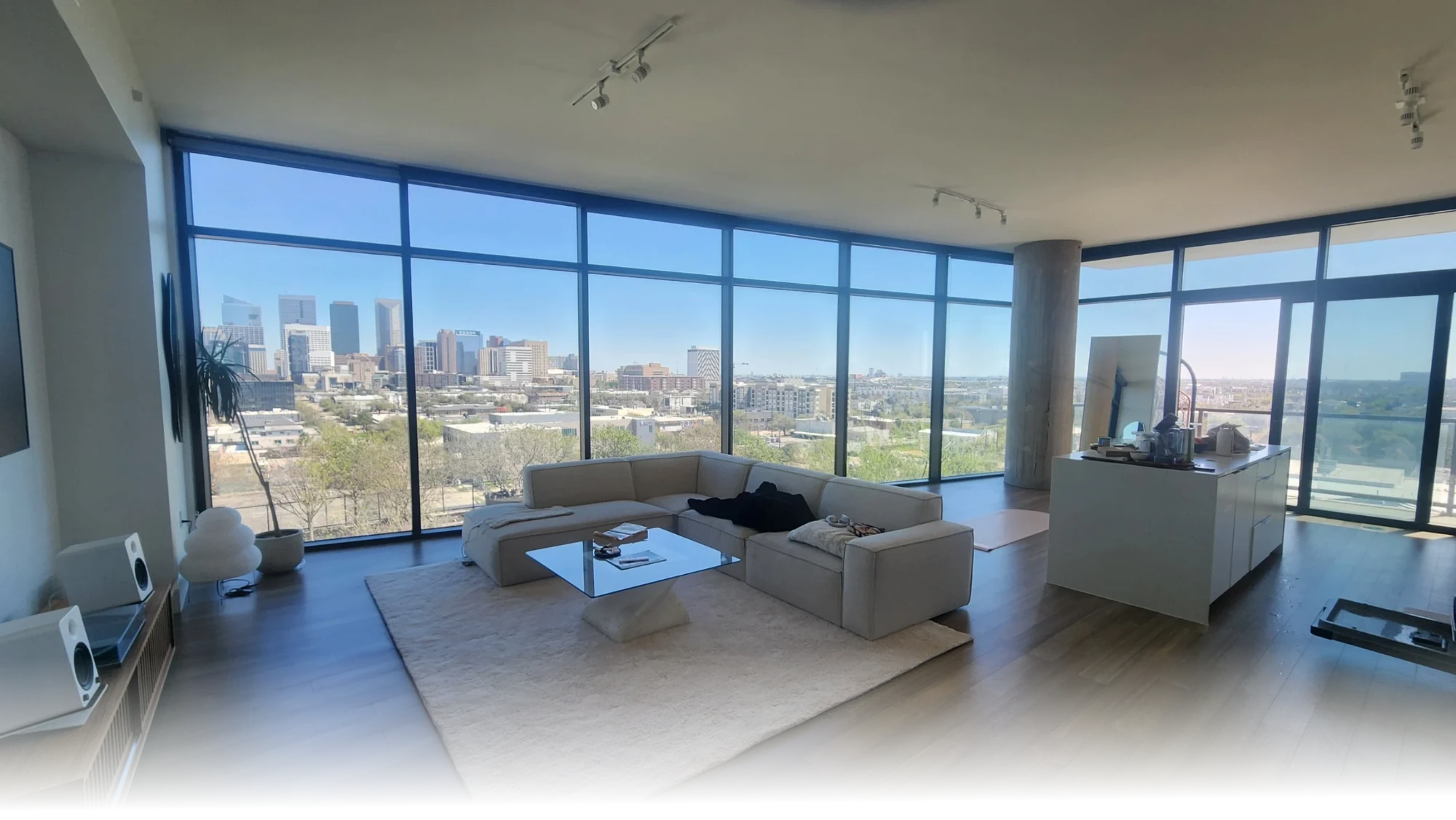 Bright high-rise apartment living room overlooking the Houston skyline, cleaned by Fouro Living